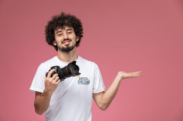 young guy giving empty hand with his photocamera