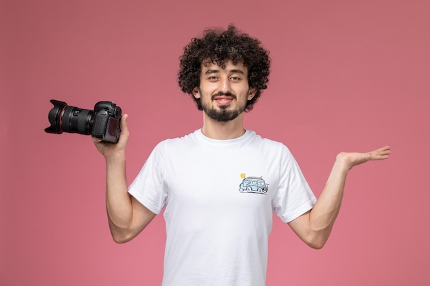 young guy giving pose with empty hand and photocamera