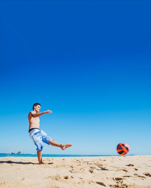 Young guy having fun with football