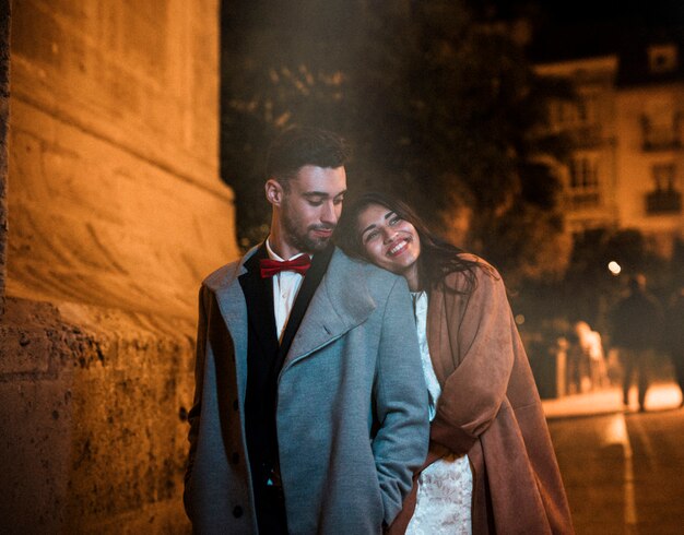 Young guy near cheerful attractive lady on street in evening