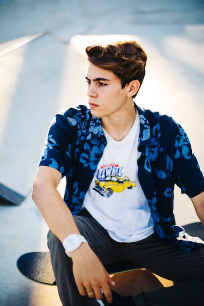 Young guy posing serious with skateboard