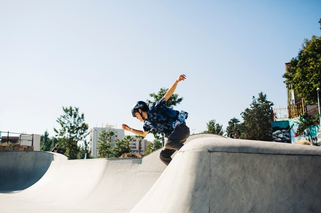 Young guy skating under the sun