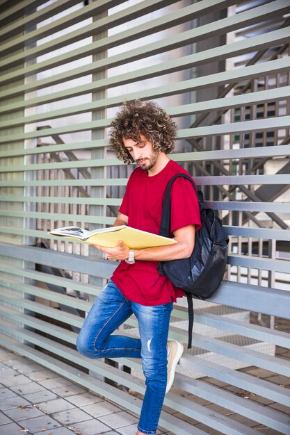 壁の近くで勉強している若い男
