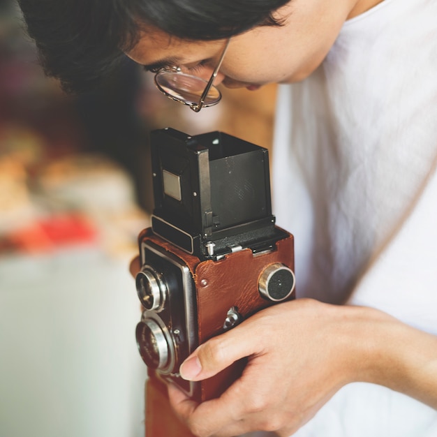 Молодой парень фотографирует с помощью старинной камеры
