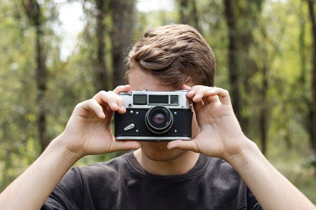 若い男が森で写真を撮る