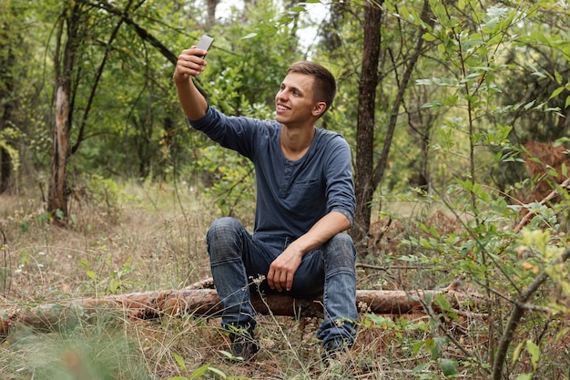 Young guy taking selfie in forest