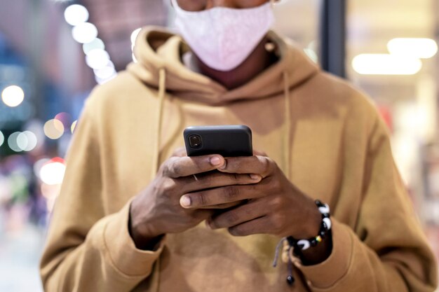 Young guy walking and texting in a city