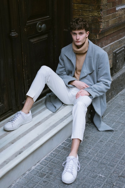 Young guy with coat sitting at front door