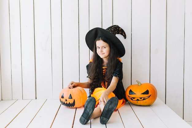 Young Halloween witch and Jack-O-Lanterns