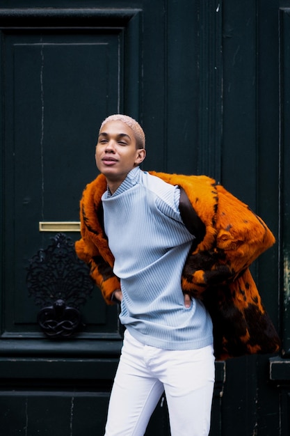 Free photo young handsome african american man posing outdoors in paris. happy smile, fashion style.