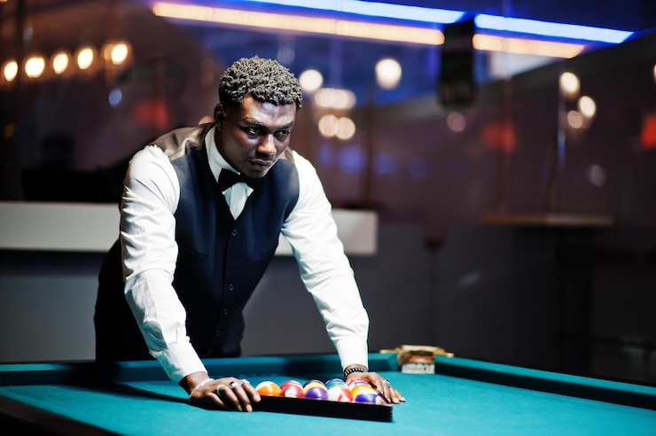 Free Photo young handsome african man wearing white shirt black vest and bow tie play pool billiard