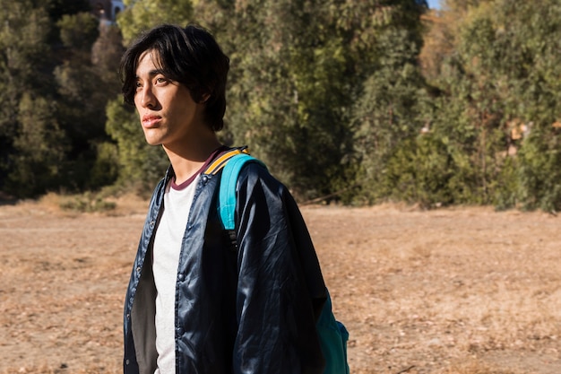 Young handsome asian man walking in nature