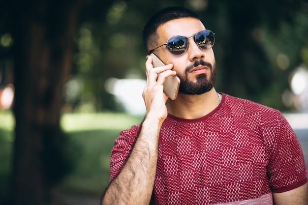 Young handsome bearded man with phone