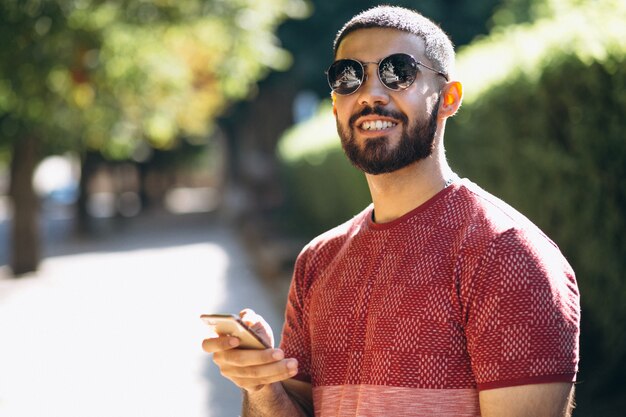 Young handsome bearded man with phone