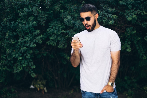 Free photo young handsome bearded man with phone