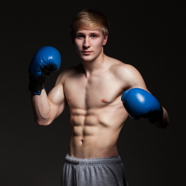 Young handsome boxer in blue gloves