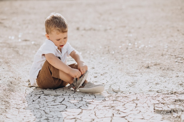 Young handsome boy sitting on the ground