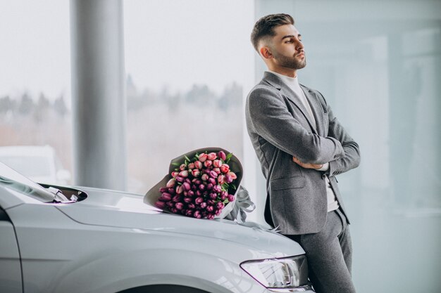 Young handsome business man delivering bouquet of beautiful flowers