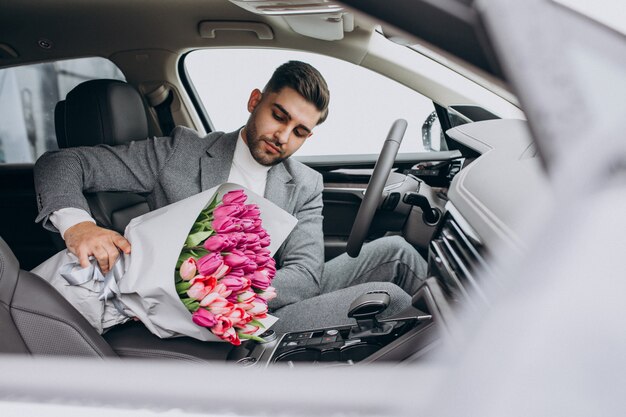 Young handsome business man delivering bouquet of beautiful flowers