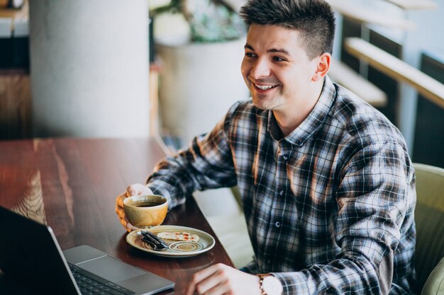 Young handsome business man using laptop in a cafe