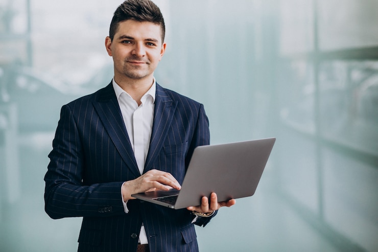 Free Photo young handsome business man with laptop in office