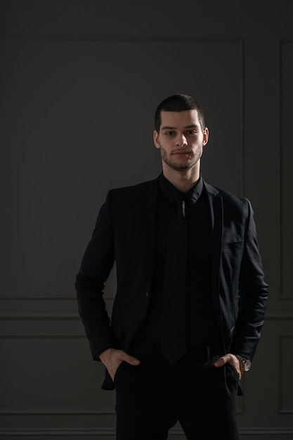 Free photo young handsome businessman in black shirt and black suit