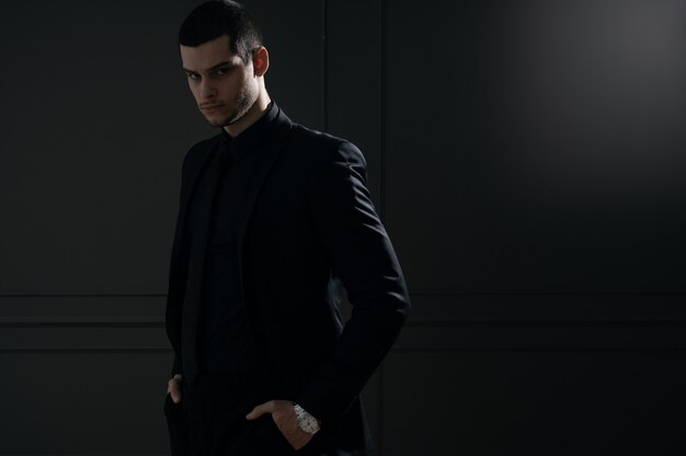 Young handsome businessman in black shirt and black suit