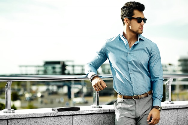 通りでサングラスでカジュアルな布で若いハンサムな実業家モデル男