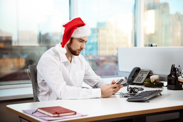 Young handsome businessman working in office on christmas day.