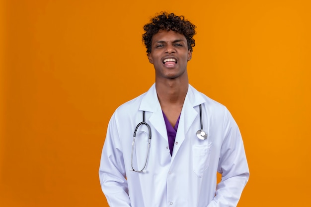 A young handsome dark-skinned man with curly hair wearing white coat with stethoscope  with open mouth 