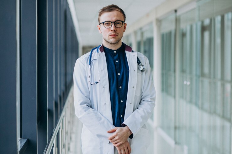 Young handsome doctor with stethoscope at clinic