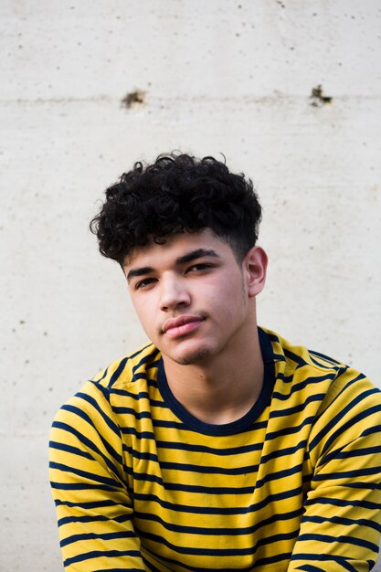 Young handsome ethnic curly man looking at camera