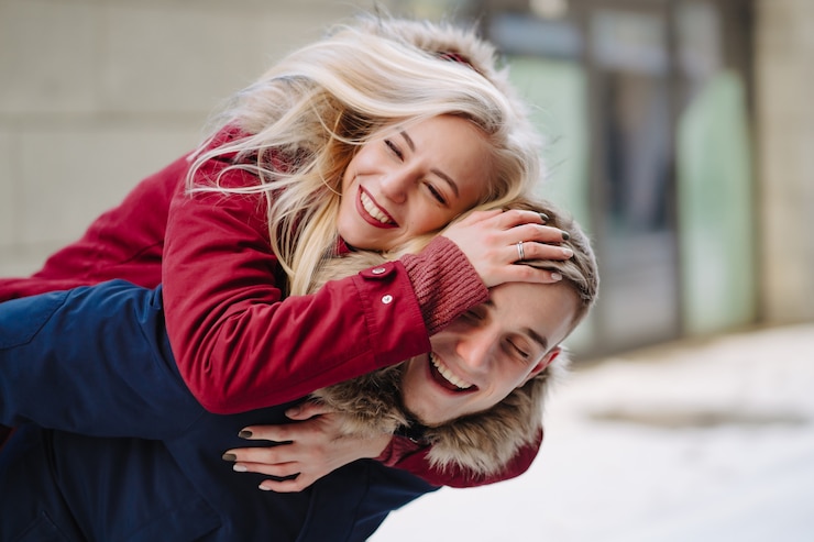 Free Photo young handsome guy giving girlfirend piggyback ride