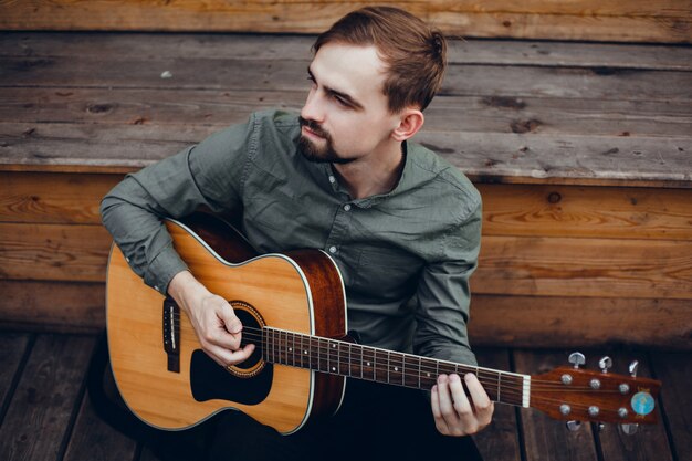 young handsome guy plays the guitar, picks up a chord, street musician