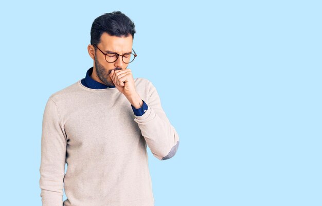 Young handsome hispanic man wearing elegant clothes and glasses feeling unwell and coughing as symptom for cold or bronchitis. health care concept.