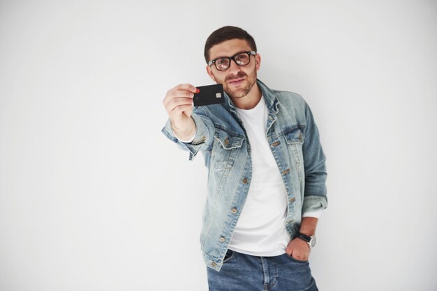 Young handsome male business executive in casual attire holding a credit card