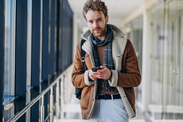 Young handsome man at airport talking on the phone