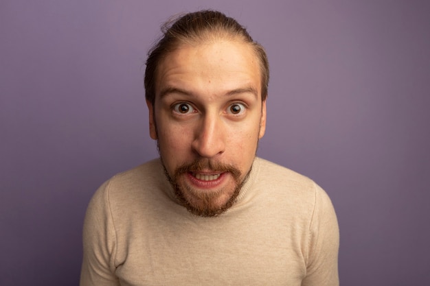 Free photo young handsome man in beige turtleneck displeased and irritated