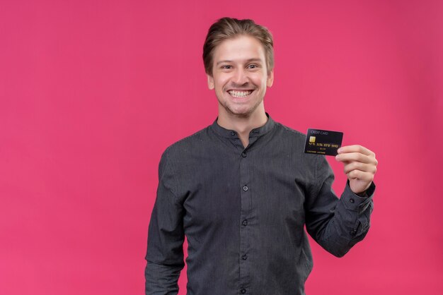 Young handsome man in black shirt holding credit card