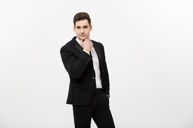 Young handsome man in black suit and glasses looking at copy-space smiling,thinking or dreaming isolated over white background