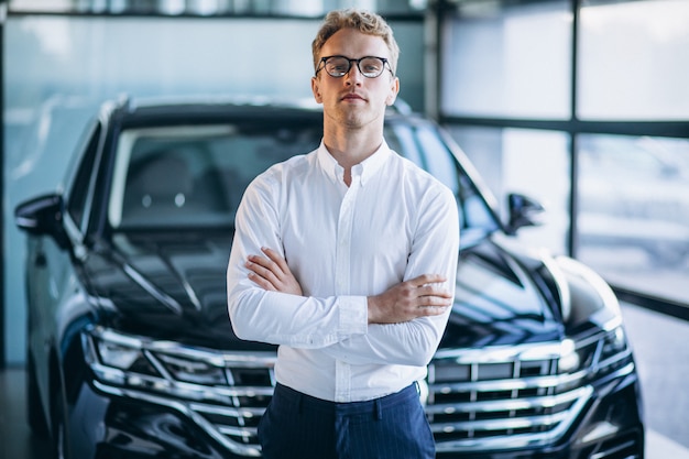 Free photo young handsome man in a car showroom