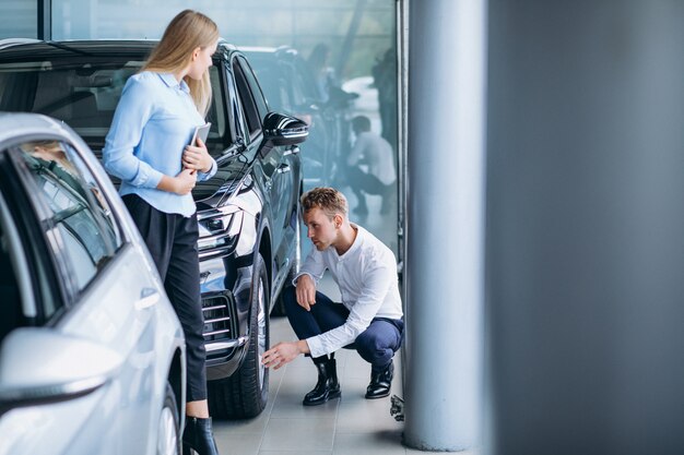 車のショールームで車を選ぶ若いハンサムな男