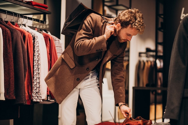 Young handsome man choosing cloth at shop