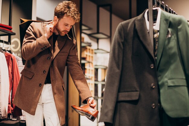 Young handsome man choosing cloth at shop