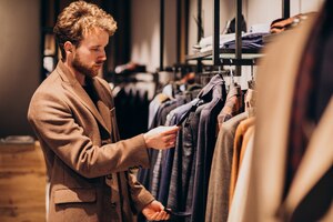 young handsome man choosing clothes at shop