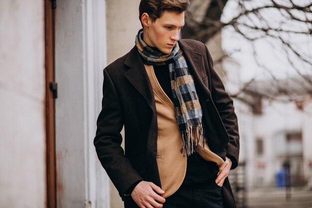 young handsome man in a coat outside the street