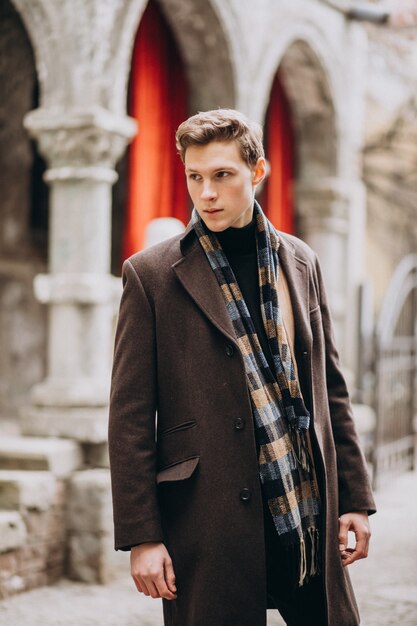 young handsome man in a coat outside the street