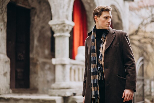 young handsome man in a coat outside the street