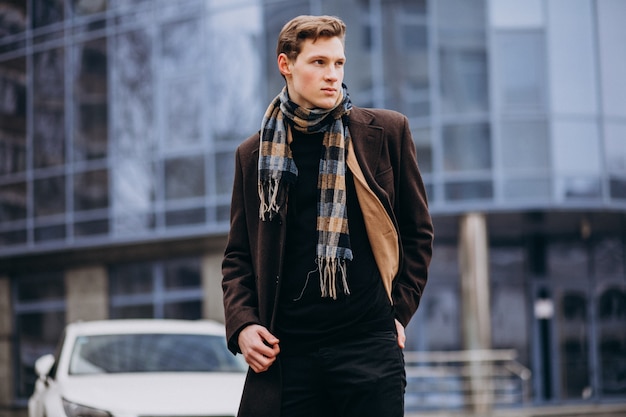 young handsome man in a coat outside the street