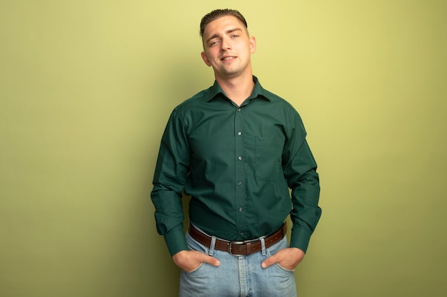 免费的照片年轻英俊的男人在绿色衬衫微笑自信的手在口袋里